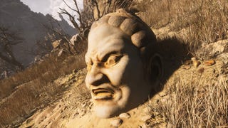 A close-up of a stone Buddha statue head in the middle of an arid landscape in Chapter 2 of Black Myth: Wukong.