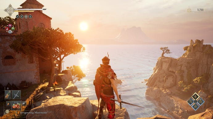 The player, brandishing a sword, stands atop a cliff and watches the sunset.