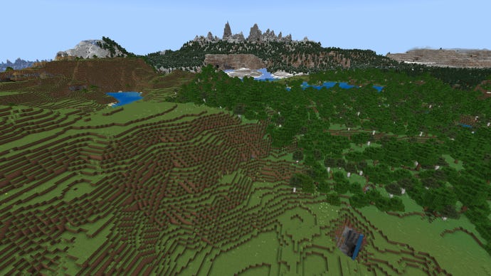 Screenshot of a rolling Minecraft landscape with plains on the left, forest on the right, and tall snowy mountains in the background.