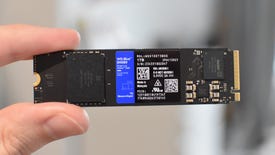 A WD Blue SN580 SSD being held between a finger and thumb.